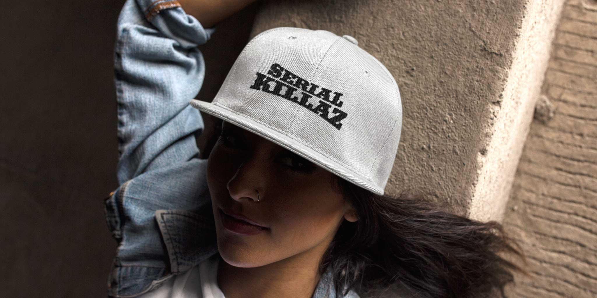 An girl laying on the floor wearing a Serial Killaz baseball cap