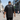 Man wearing black oversized SUB50Hz t-shirt back print walking urban street